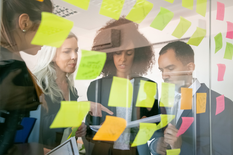 marketers working on a b2b saas marketing project by putting sticky notes on the wall